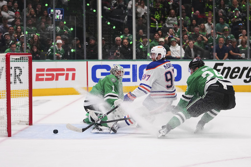 Edmonton Oilers center Connor McDavid (97) scores against Dallas Stars goaltender Casey DeSmith (1) and center Roope Hintz (24) during the second period of Game 5 of the Western Conference finals in the NHL hockey Stanley Cup playoffs, Thursday, May 29, 2025, in Dallas. (AP Photo/Julio Cortez)
