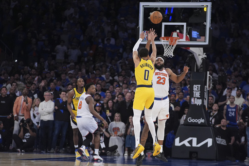 Indiana Pacers guard Tyrese Haliburton (0) shoots a 2-point shot against New York Knicks center Mitchell Robinson (23) to tie the score at the end of regulation in Game 1 of the NBA basketball Eastern Conference final, Wednesday, May 21, 2025, in New York. (AP Photo/Frank Franklin II)