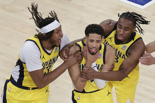 Indiana Pacers guard Tyrese Haliburton (0) is mobbed by teammates as he makes a choking motion after hitting a shot against the New York Knicks at the end of regulation to tie Game 1 of the NBA basketball Eastern Conference final, Wednesday, May 21, 2025, in New York. (AP Photo/Adam Hunger)