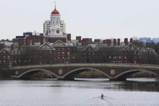 FILE - A sculler rows down the Charles River near Harvard University, at rear, April 15, 2025, in Cambridge, Mass. (AP Photo/Charles Krupa, File)
