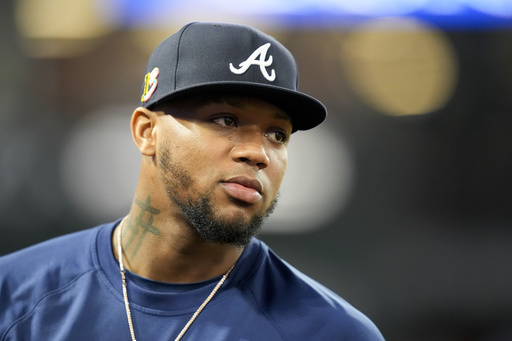 FILE - Atlanta Braves' Ronald Acuna Jr. stands in the dugout during the fifth inning of a baseball game against the Los Angeles Angels, on Aug. 17, 2024, in Anaheim, Calif. (AP Photo/Ryan Sun, File)