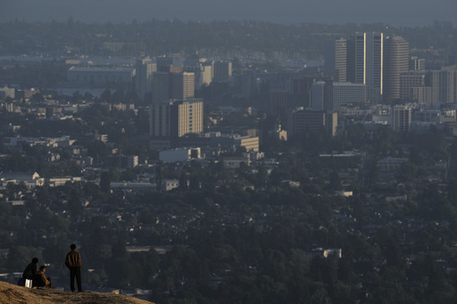 People stop on a trail facing downtown Oakland, Tuesday, May 27, 2025, in Berkeley, Calif. (AP Photo/Godofredo A. Vásquez)