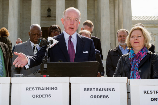 FILE - Dr. Steven Hotze, president of Conservative Republicans of Texas, speaks at a Restrain the Judges news conference, while Janet Porter of Faith2Action listens at right, in front of the Supreme Court in Washington, April 27, 2015. (AP Photo/Cliff Owen, File)