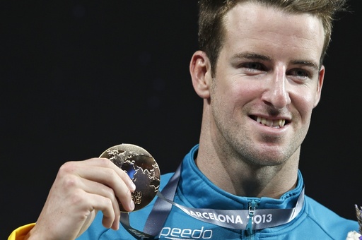 FILE - Australia's James Magnussen smiles as he hold the gold medal he won in the Men's 100m freestyle final at the FINA Swimming World Championships in Barcelona, Spain, on Aug. 1, 2013. (AP Photo/Michael Sohn, File)
