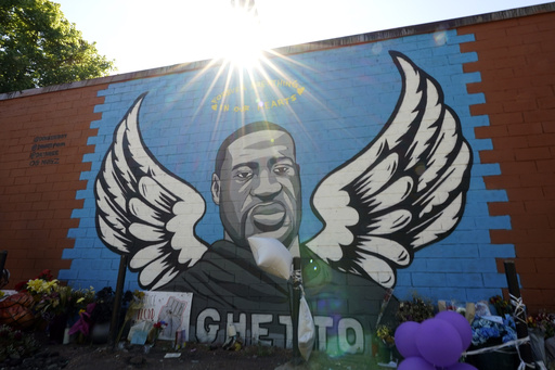 FILE - The sun shines above a mural honoring George Floyd in Houston's Third Ward on Sunday, June 7, 2020. (AP Photo/David J. Phillip, File)