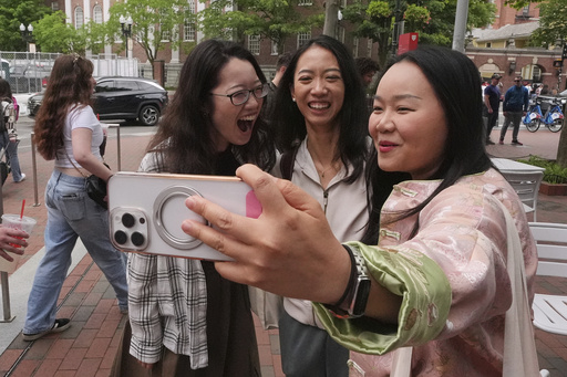 Yurong "Luanna" Jiang, center, who delivered a speech at her Harvard University commencement, takes a selfie with her college friends Cynthia Luo, right, and Helen Ji, Friday, May 30, 2025, in Cambridge, Mass. (AP Photo/Charles Krupa)
