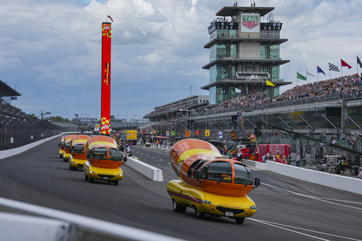 The Oscar Mayer Wienermobiles head into the first turn as they compete in the Wienie 500 following the practice session for the Indianapolis 500 auto race at Indianapolis Motor Speedway in Indianapolis, Friday, May 23, 2025. (AP Photo/Michael Conroy)