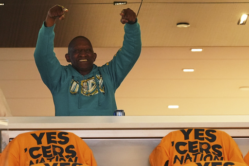 John Halliburton, father of Indiana Pacers guard Tyrese Haliburton, raises his hands from a suite before Game 4 of the Eastern Conference finals of the NBA basketball playoffs against the New York Knicks in Indianapolis, Tuesday, May 27, 2025. (AP Photo/Michael Conroy)
