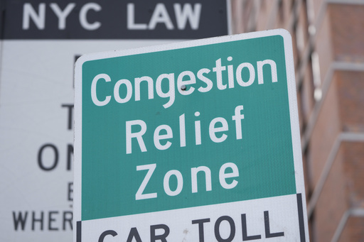 FILE - Signs, including some advising drivers of congestion pricing tolls, are displayed near the exit of the Lincoln Tunnel in New York, Feb. 19, 2025. (AP Photo/Seth Wenig, File)