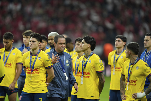 America's coach Andre Jardine and his players stand on the pitch with their second place medals after losing 0-2 against Toluca during the Mexican soccer league second leg final match at Nemesio Diez stadium in Toluca, Mexico, Sunday, May 25, 2025. (AP Photo/Fernando Llano)