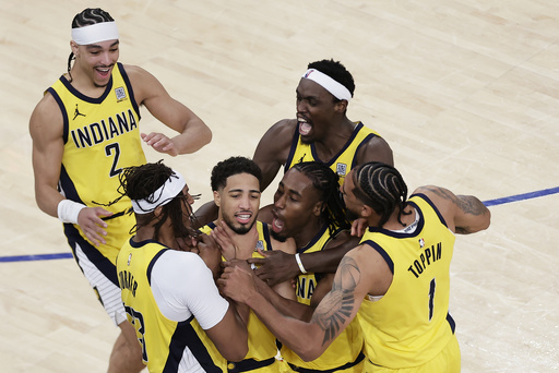 Indiana Pacers guard Tyrese Haliburton (0) is mobbed by teammates as he makes a choking motion after hitting a shot against the New York Knicks at the end of regulation to tie Game 1 of the NBA basketball Eastern Conference final, Wednesday, May 21, 2025, in New York. (AP Photo/Adam Hunger)
