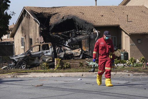 Authorities work the scene where a small plane crashed into a San Diego neighborhood, setting several homes on fire and forcing evacuations along several blocks early Thursday, May 22, 2025. (AP Photo/Gregory Bull)