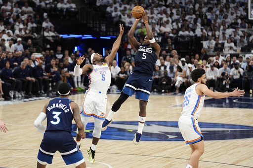 Minnesota Timberwolves guard Anthony Edwards, center right, shoots against Oklahoma City Thunder guard Luguentz Dort, center left, during the first half of Game 3 of the Western Conference finals of the NBA basketball playoffs, Saturday, May 24, 2025, in Minneapolis. (AP Photo/Abbie Parr)