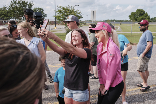 A fan takes a photo with Savannah Chrisley, daughter of reality television star Todd Chrisley, after she spoke outside the Federal Prison Camp, Wednesday, May 28, 2025, in Pensacola, Fla. (AP Photo/Dan Anderson)