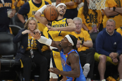 Indiana Pacers guard Andrew Nembhard (2) rebounds over Oklahoma City Thunder guard Luguentz Dort during the second half of Game 6 of the NBA Finals basketball series, Thursday, June 19, 2025, in Indianapolis. (AP Photo/Michael Conroy)
