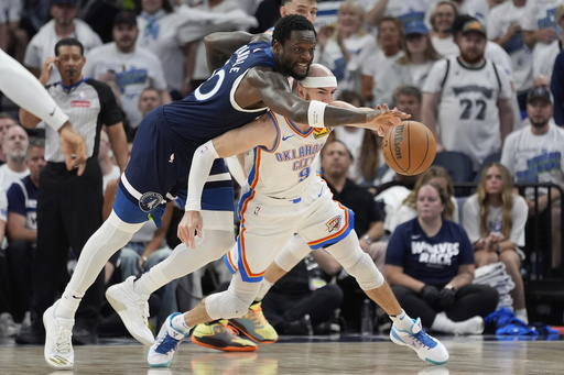 Minnesota Timberwolves forward Julius Randle, top, reaches to steal the ball over Oklahoma City Thunder guard Alex Caruso during the second half of Game 4 of the Western Conference finals of the NBA basketball playoffs Monday, May 26, 2025, in Minneapolis. (AP Photo/Abbie Parr)