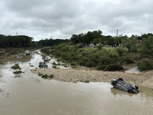 Vehicles sit in the river after being swept away by floodwaters in San Antonio, Tx., Thursday, June 12, 2025. (AP Photo/Lekan Oyekanmi)