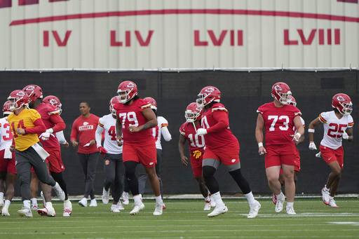 Kansas City Chiefs players warm up before the NFL football team's practice Tuesday, June 17, 2025, in Kansas City, Mo. (AP Photo/Charlie Riedel)