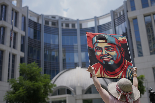 Katheryn Millwee holds a portrait of Kilmar Abrego Garcia outside the federal courthouse Wednesday, June 25, 2025, in Nashville, Tenn. (AP Photo/George Walker IV)