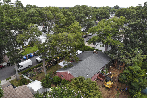 FILE - Authorities work at the home of suspect Rex Heuermann, bottom right, in Massapequa Park, N.Y., July 24, 2023. Heuermann has been charged with killing at least three women in the long-unsolved slayings known as the Gilgo Beach killings. (AP Photo/Seth Wenig, File)