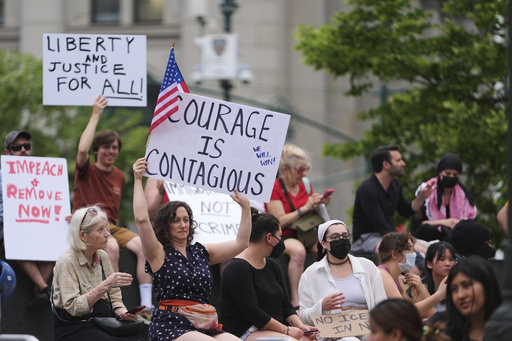 Demonstrators hold signs during a protest against deportation by Immigration and Customs Enforcement Thursday, June 12, 2025, in New York. (AP Photo/Frank Franklin II)
