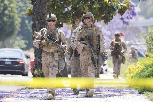 U.S Marines work outside of a federal building, Friday, June 13, 2025, in Los Angeles (AP Photo/Damian Dovarganes)