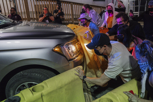 Protesters attempt to block a vehicle from leaving the Delaney Hall Detention Facility during protests over federal immigration enforcement raids on Thursday, June 12, 2025, in Newark, N.J. (AP Photo/Olga Fedorova)