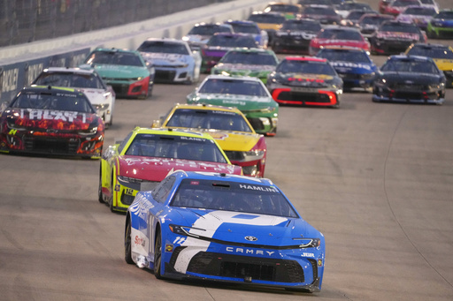 Denny Hamlin (11) leads the pack of cars through turn three during a NASCAR Cup Series auto race Sunday, June 1, 2025, in Lebanon, Tenn. (AP Photo/George Walker IV)