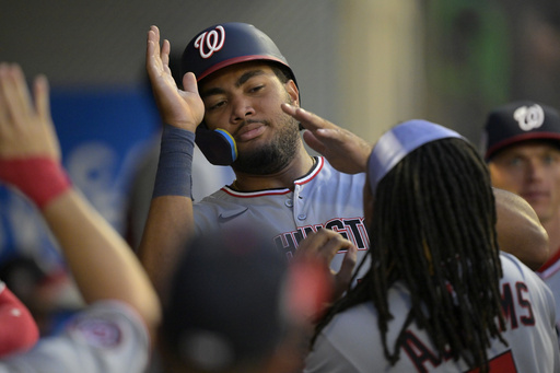 Washington Nationals' James Wood is greeted in the dugout after scoring on a double by Nathaniel Lowe during the fifth inning of a baseball game against the Los Angeles Angels, Friday, June 27, 2025, in Anaheim, Calif. (AP Photo/Jayne Kamin-Oncea)