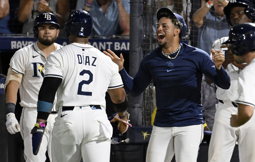 Tampa Bay Rays' Yandy Díaz (2) and Christopher Morel, right, celebrate after Diaz scored on a single by Junior Caminero, not pictured, during the seventh inning of a baseball game against the Baltimore Orioles, Wednesday, June 18, 2025, in Tampa, Fla. (AP Photo/Jason Behnken)