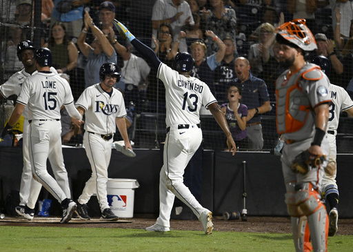 Tampa Bay Rays' Josh Lowe (15) and Junior Caminero (13) celebrate after scoring on a Jonathan Aranda single during the seventh inning of a baseball game against the Baltimore Orioles, Wednesday, June 18, 2025, in Tampa, Fla. (AP Photo/Jason Behnken)