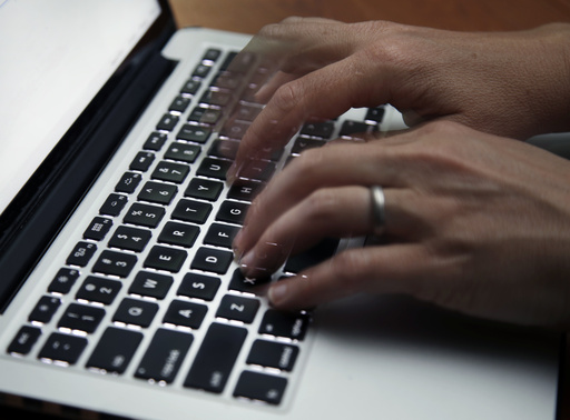 FILE - This June 19, 2017 file photo shows a person working on a laptop in North Andover, Mass. (AP Photo/Elise Amendola, File)