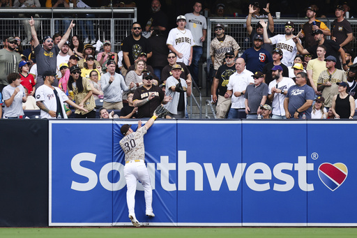 San Diego Padres left fielder Gavin Sheets (30) attempts to catch a fly ball at the wall hit by Pittsburgh Pirates' Adam Frazier in the fourth inning of a baseball game Sunday, June 1, 2025, in San Diego. (AP Photo/Derrick Tuskan)