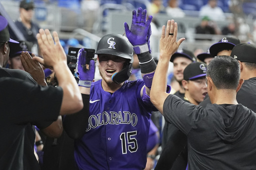 Colorado Rockies' Hunter Goodman (15) is congratulated in the dugout after hitting a solo home run during the eighth inning of a baseball game against the Miami Marlins, Tuesday, June 3, 2025, in Miami. (AP Photo/Lynne Sladky)