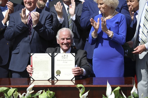 Republican South Carolina Gov. Henry McMaster holds up a ceremonial copy of a bill he signed changing South Carolina's energy laws on Wednesday, June 18, 2025, in Columbia, S.C. (AP Photo/Jeffrey Collins)