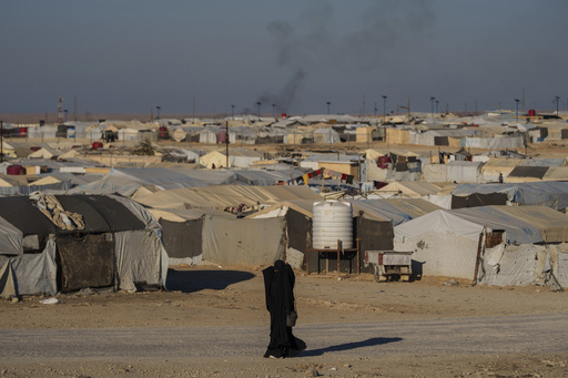 FILE - A woman walks in the al-Hol camp in northeastern Syria's Hasakeh province, where tens of thousands of mostly women and children linked to the Islamic State group have been living for years, Thursday, Jan. 30, 2025. (AP Photo/Bernat Armangue,File)