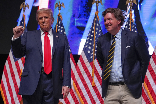 FILE - Republican presidential nominee former President Donald Trump speaks with Tucker Carlson during a Tucker Carlson Live Tour show at Desert Diamond Arena, Oct. 31, 2024, in Glendale, Ariz. (AP Photo/Julia Demaree Nikhinson, File)