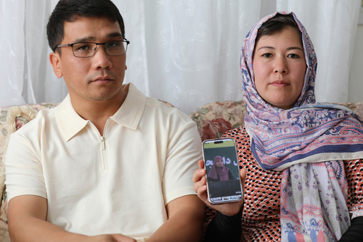 Mohammad Sharafoddin, left, and his wife, Nuriya, right, show a photo of their niece in Afghanistan who won't be able to travel to the U.S., under the new travel ban, during an interview at their home in Irmo, S.C., on Saturday, June 7 2025. (AP Photo/Jeffrey Collins)