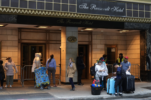 FILE - Members of the Goya family wait for a ride, with their belongings, in front of the Roosevelt Hotel in New York, Tuesday, Feb. 25, 2025. (AP Photo/Seth Wenig, File)