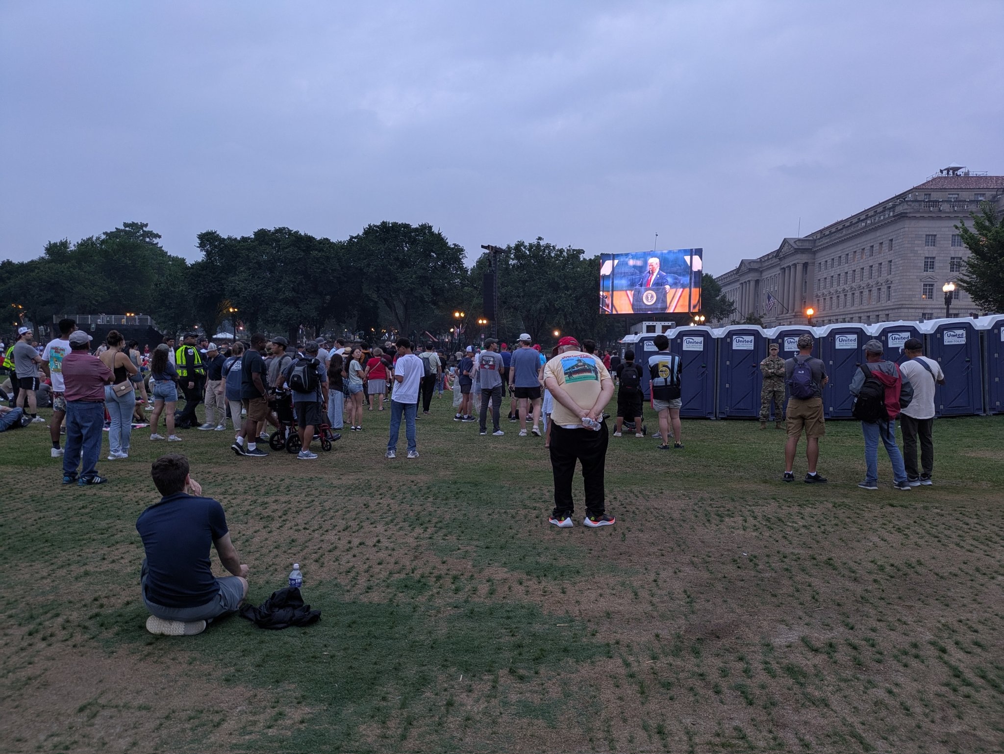 President Donald Trump's speech was displayed on large screens as people watched near the Washington Monument at the conclusion of the Army parade on June 14, 2025. (Photo by Ashley Murray/States Newsroom)