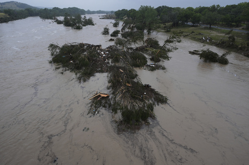 A raging Guadalupe River leaves fallen trees and debris in its wake, Friday, July 4, 2025, in Kerrville, Texas. (AP Photo/Eric Gay)