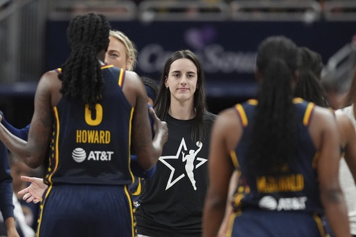 Indiana Fever's Caitlin Clark, middle greets teammates during the first half of a WNBA basketball game against the Las Vegas Aces, Thursday, July 3, 2025, in Indianapolis. (AP Photo/Michael Conroy)