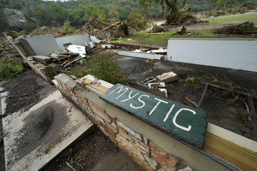 A Camp Mystic sign is seen near the entrance to the establishment along the banks of the Guadalupe River after a flash flood swept through the area in Hunt, Texas, Saturday, July 5, 2025. (AP Photo/Julio Cortez)