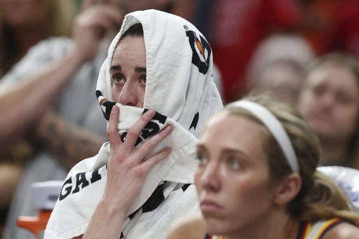 Indiana Fever's Caitlin Clark sits on the bench after an apparent injury during the second half of a WNBA basketball game against the Connecticut Sun, Tuesday, July 15, 2025, in Boston. (AP Photo/Michael Dwyer)