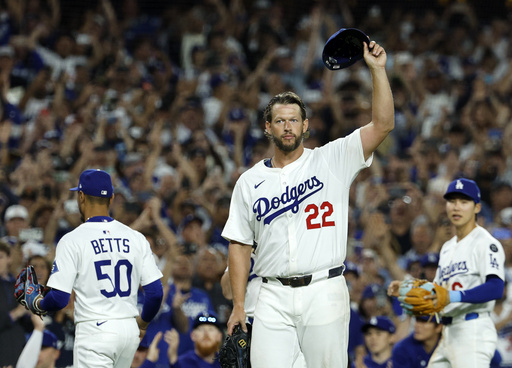 Los Angeles Dodgers pitcher Clayton Kershaw (22) tips his cap after recording his 3,000th career strike out by striking out Chicago White Sox's Vinny Capra during the sixth inning of a baseball game Wednesday, July 2, 2025, in Los Angeles. (AP Photo/Kevork Djansezian)