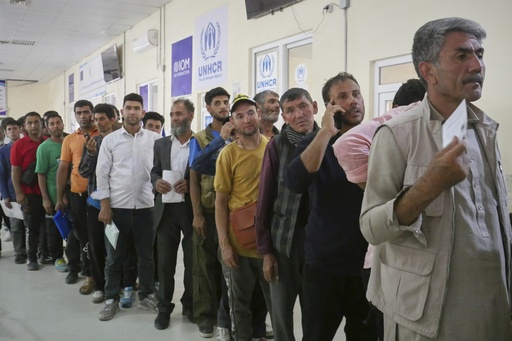 Afghan refugees who returned after fleeing Iran to escape deportation and conflict line up at a UNHCR facility near the Islam Qala crossing in western Herat province, Afghanistan, on Friday, June 20, 2025. (AP Photo/Omid Haqjoo)