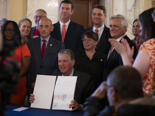 Rhode Island Gov. Dan McKee presents a signed bill that bans the sale of assault-style weapons in the state of Rhode Island at the Rhode Island Statehouse in Providence, Thursday, June 26, 2025. (AP Photo/Sydney Roth)