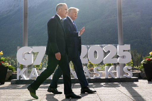 Canada's Prime Minister Mark Carney walks with President Donald Trump after a group photo at the G7 Summit, Monday, June 16, 2025, in Kananaskis, Canada. (AP Photo/Mark Schiefelbein)