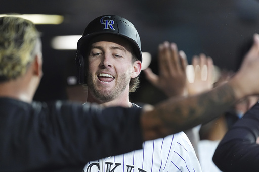 Colorado Rockies' Orlando Arcia, left, congratulates Ryan McMahon as he returns to the dugout after hitting a two-run home run off St. Louis Cardinals starting pitcher Erick Fedde in the third inning of a baseball game Tuesday, July 22, 2025, in Denver. (AP Photo/David Zalubowski)
