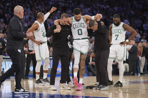 FILE - Trainers help Boston Celtics' Jayson Tatum (0) off the court after he was injured during the second half of Game 4 in the Eastern Conference semifinals of the NBA basketball playoffs against the New York Knicks, May 12, 2025, in New York. (AP Photo/Frank Franklin II, File)